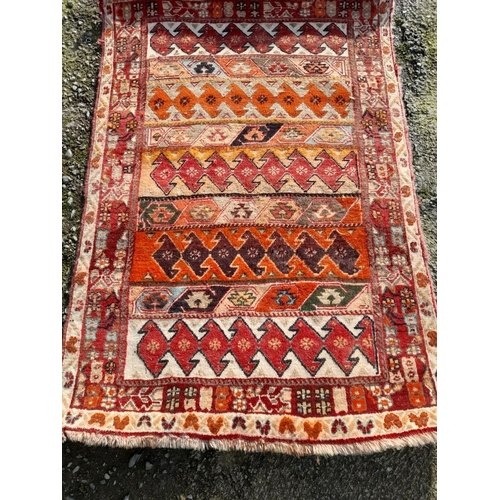 251 - A GOOD QUALITY MEDIUM SIZED TRIBAL RUG, featuring multiple geometric patterns in vibrant tones. In n... 