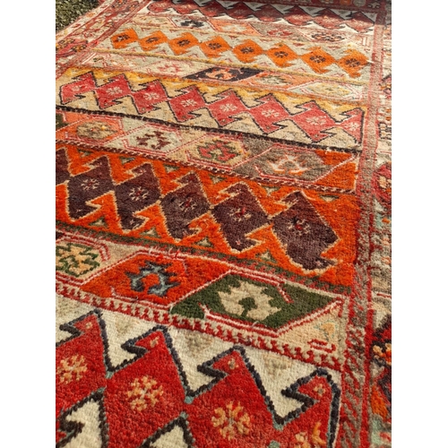 251 - A GOOD QUALITY MEDIUM SIZED TRIBAL RUG, featuring multiple geometric patterns in vibrant tones. In n... 