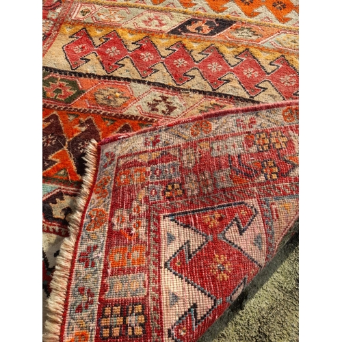 251 - A GOOD QUALITY MEDIUM SIZED TRIBAL RUG, featuring multiple geometric patterns in vibrant tones. In n... 