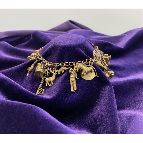 26 - A BEAUTIFUL 9CT YELLOW GOLD CHARM BRACELET, the chain is 9ct gold marked 375, with a wonderful array... 