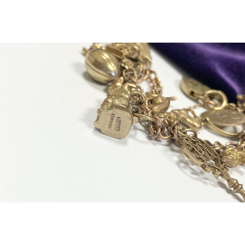 26 - A BEAUTIFUL 9CT YELLOW GOLD CHARM BRACELET, the chain is 9ct gold marked 375, with a wonderful array... 