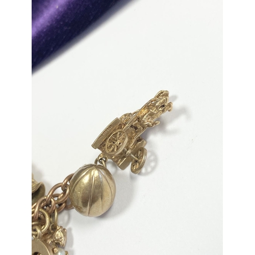 26 - A BEAUTIFUL 9CT YELLOW GOLD CHARM BRACELET, the chain is 9ct gold marked 375, with a wonderful array... 