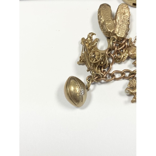 26 - A BEAUTIFUL 9CT YELLOW GOLD CHARM BRACELET, the chain is 9ct gold marked 375, with a wonderful array... 