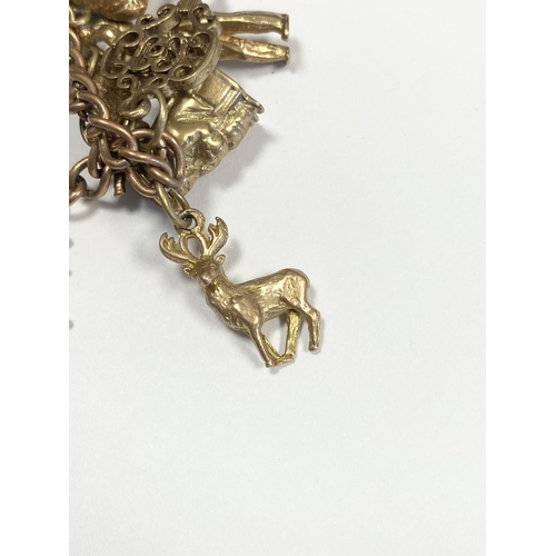 26 - A BEAUTIFUL 9CT YELLOW GOLD CHARM BRACELET, the chain is 9ct gold marked 375, with a wonderful array... 