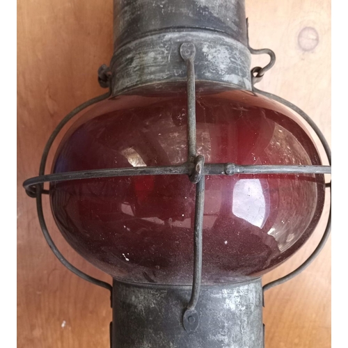 285 - AN ORIGINAL EARLY 20TH CENTURY (WORLD WAR I) SHIPS LAMP, with ruby glass shade and oil burner. Dimen... 