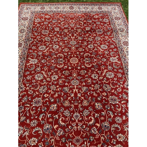 313 - A VIBRANT TURKISH STYLE RUG, excellent quality, the centre with foliate designs on red ground, surro... 