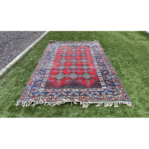 314 - A TURKISH KAZAK STYLE RUG, the centre with rows of geometric patterns on red ground, surrounded by m... 