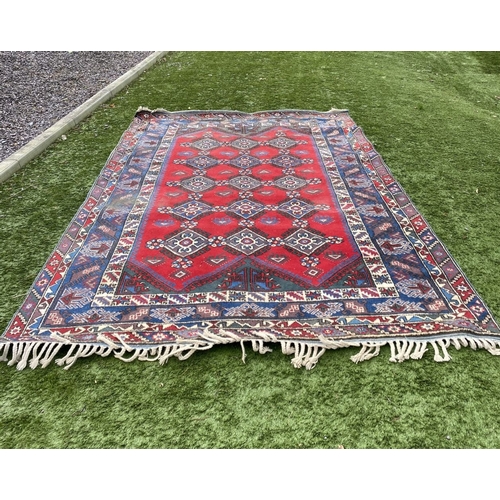 314 - A TURKISH KAZAK STYLE RUG, the centre with rows of geometric patterns on red ground, surrounded by m... 