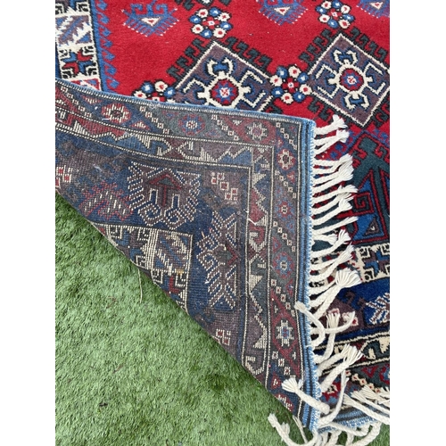 314 - A TURKISH KAZAK STYLE RUG, the centre with rows of geometric patterns on red ground, surrounded by m... 