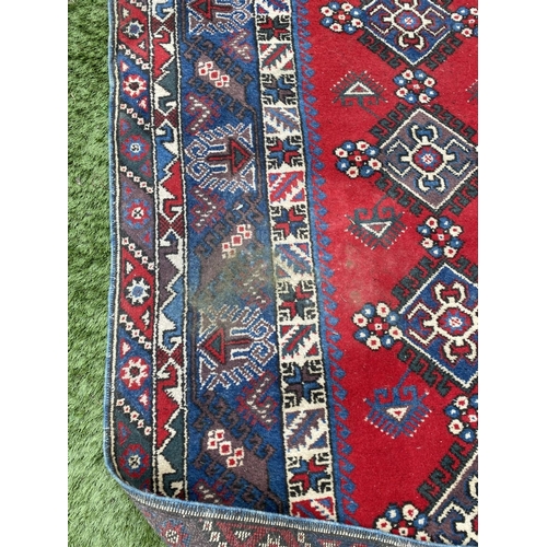 314 - A TURKISH KAZAK STYLE RUG, the centre with rows of geometric patterns on red ground, surrounded by m... 