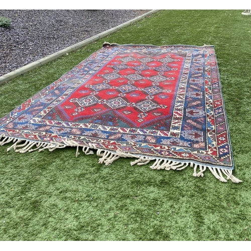 314 - A TURKISH KAZAK STYLE RUG, the centre with rows of geometric patterns on red ground, surrounded by m... 