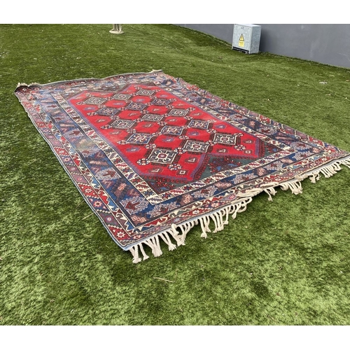 314 - A TURKISH KAZAK STYLE RUG, the centre with rows of geometric patterns on red ground, surrounded by m... 