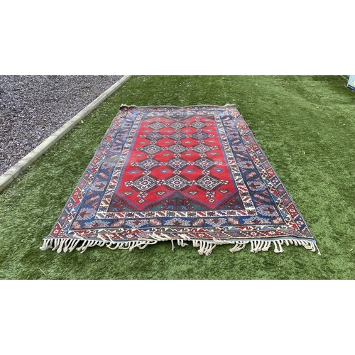 314 - A TURKISH KAZAK STYLE RUG, the centre with rows of geometric patterns on red ground, surrounded by m... 