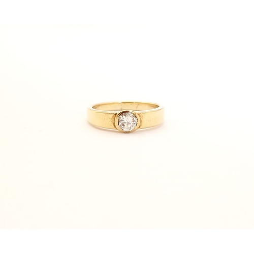 36 - A VINTAGE 18CT YELLOW GOLD SOLITAIRE RING, the bezel set ¼ carat diamond is held to the centre of th... 