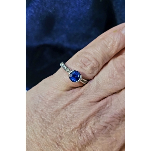 37 - AN 18CT WHITE GOLD DIAMOND & SAPPHIRE RING, with a round cut blue sapphire in a raised setting, with... 