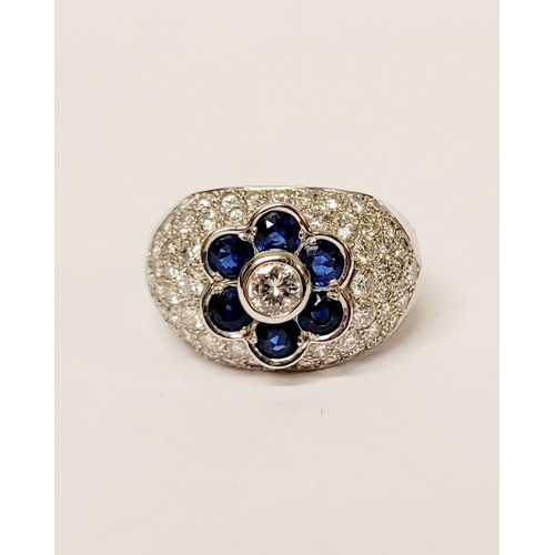 39 - A PRETTY 18CT WHITE GOLD SAPPHIRE & DIAMOND FLORAL CLUSTER / DRESS BOMBÉ SHAPED RING, the curved set... 