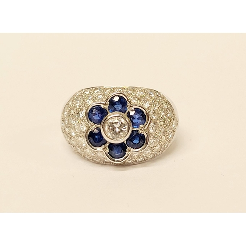 39 - A PRETTY 18CT WHITE GOLD SAPPHIRE & DIAMOND FLORAL CLUSTER / DRESS BOMBÉ SHAPED RING, the curved set... 