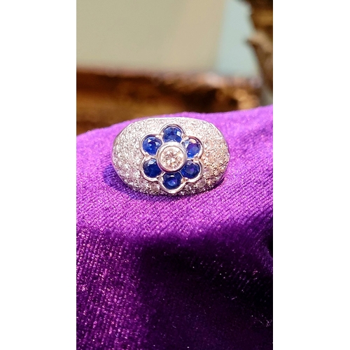 39 - A PRETTY 18CT WHITE GOLD SAPPHIRE & DIAMOND FLORAL CLUSTER / DRESS BOMBÉ SHAPED RING, the curved set... 