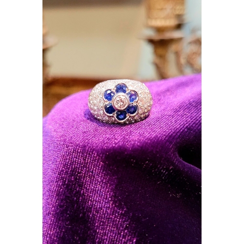 39 - A PRETTY 18CT WHITE GOLD SAPPHIRE & DIAMOND FLORAL CLUSTER / DRESS BOMBÉ SHAPED RING, the curved set... 