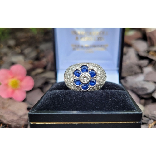 39 - A PRETTY 18CT WHITE GOLD SAPPHIRE & DIAMOND FLORAL CLUSTER / DRESS BOMBÉ SHAPED RING, the curved set... 