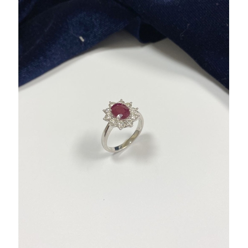 64 - AN 18CT WHITE GOLD BURMESE RUBY & DIAMOND CLUSTER RING, with central oval cut Burmese ruby in four c... 