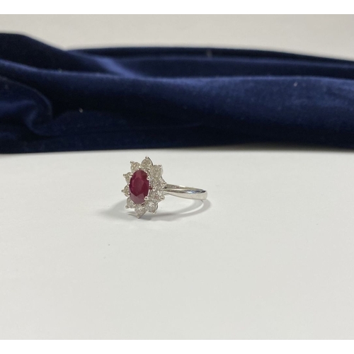 64 - AN 18CT WHITE GOLD BURMESE RUBY & DIAMOND CLUSTER RING, with central oval cut Burmese ruby in four c... 