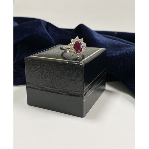 64 - AN 18CT WHITE GOLD BURMESE RUBY & DIAMOND CLUSTER RING, with central oval cut Burmese ruby in four c... 