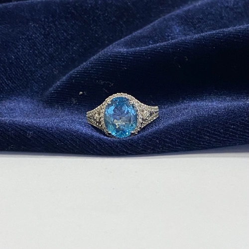 7 - AN 18CT WHITE GOLD BLUE TOPAZ & DIAMOND CLUSTER RING, complete with diamond encrusted shoulders, vib... 