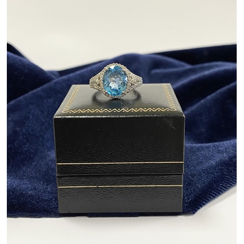 7 - AN 18CT WHITE GOLD BLUE TOPAZ & DIAMOND CLUSTER RING, complete with diamond encrusted shoulders, vib... 