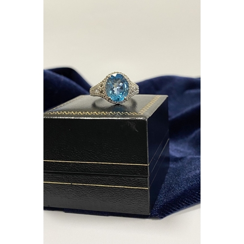 7 - AN 18CT WHITE GOLD BLUE TOPAZ & DIAMOND CLUSTER RING, complete with diamond encrusted shoulders, vib... 