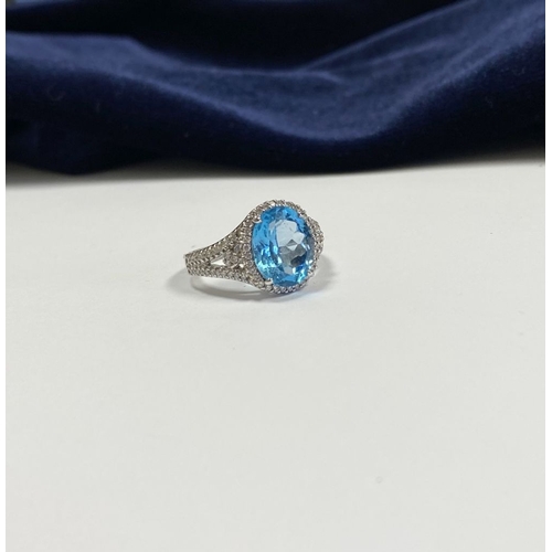 7 - AN 18CT WHITE GOLD BLUE TOPAZ & DIAMOND CLUSTER RING, complete with diamond encrusted shoulders, vib... 