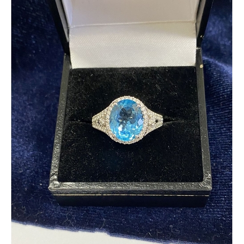 7 - AN 18CT WHITE GOLD BLUE TOPAZ & DIAMOND CLUSTER RING, complete with diamond encrusted shoulders, vib... 