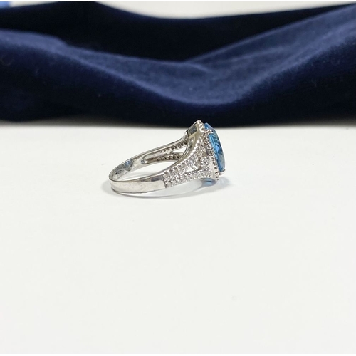 7 - AN 18CT WHITE GOLD BLUE TOPAZ & DIAMOND CLUSTER RING, complete with diamond encrusted shoulders, vib... 