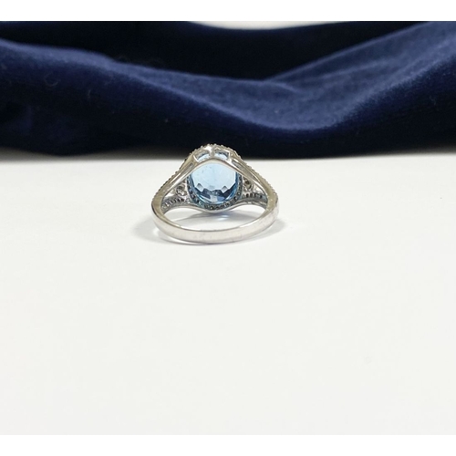 7 - AN 18CT WHITE GOLD BLUE TOPAZ & DIAMOND CLUSTER RING, complete with diamond encrusted shoulders, vib... 