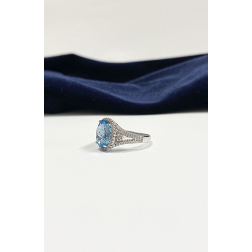 7 - AN 18CT WHITE GOLD BLUE TOPAZ & DIAMOND CLUSTER RING, complete with diamond encrusted shoulders, vib... 