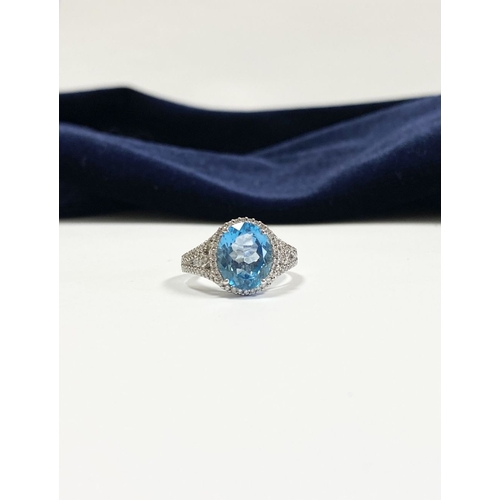 7 - AN 18CT WHITE GOLD BLUE TOPAZ & DIAMOND CLUSTER RING, complete with diamond encrusted shoulders, vib... 