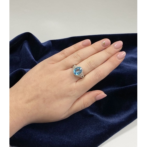 7 - AN 18CT WHITE GOLD BLUE TOPAZ & DIAMOND CLUSTER RING, complete with diamond encrusted shoulders, vib... 