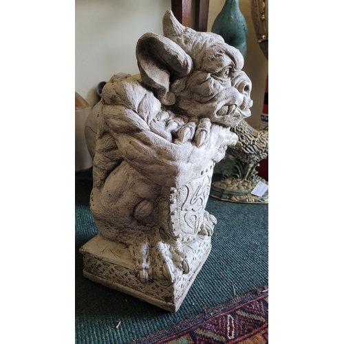 76 - A STONE GARDEN ORNAMENT IN THE FORM OF GARGOYLE WITH SHIELD, dimensions: 39cm high approx.