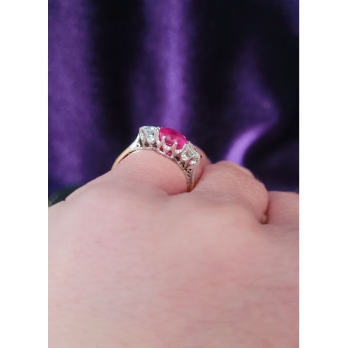 86 - A LOVELY THREE STONE DIAMOND & RUBY RING, with a central bright pink Burma ruby round cut stone, fla... 