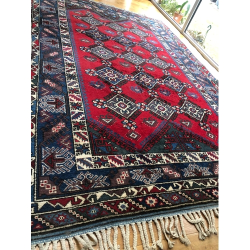 314 - A TURKISH KAZAK STYLE RUG, the centre with rows of geometric patterns on red ground, surrounded by m... 