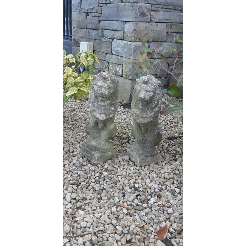 111 - A PAIR OF COMPOSITE GARDEN ORNAMENTS, in the form of seated lions, wear as photographed. Dimensions:... 