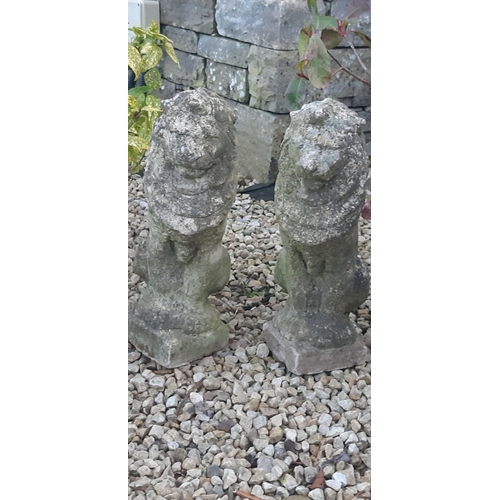 111 - A PAIR OF COMPOSITE GARDEN ORNAMENTS, in the form of seated lions, wear as photographed. Dimensions:... 