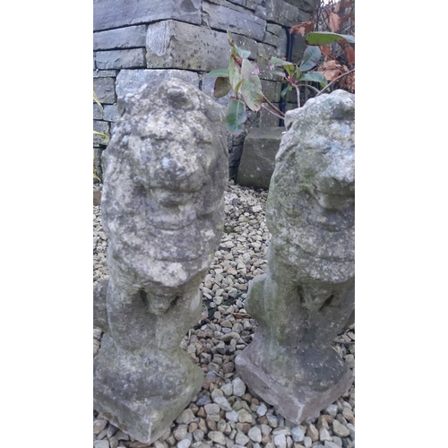 111 - A PAIR OF COMPOSITE GARDEN ORNAMENTS, in the form of seated lions, wear as photographed. Dimensions:... 