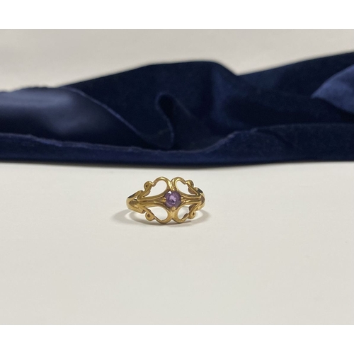 121 - A PRETTY 9CT YELLOW GOLD AMETHYST RING, with central round cut amethyst, in ornate scrolling openwor... 