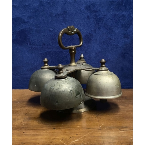 131 - AN ANTIQUE SACRISTY BELL, brass with handle, four bells, three with clappers, on circular base. Dime... 