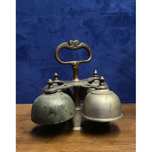 131 - AN ANTIQUE SACRISTY BELL, brass with handle, four bells, three with clappers, on circular base. Dime... 