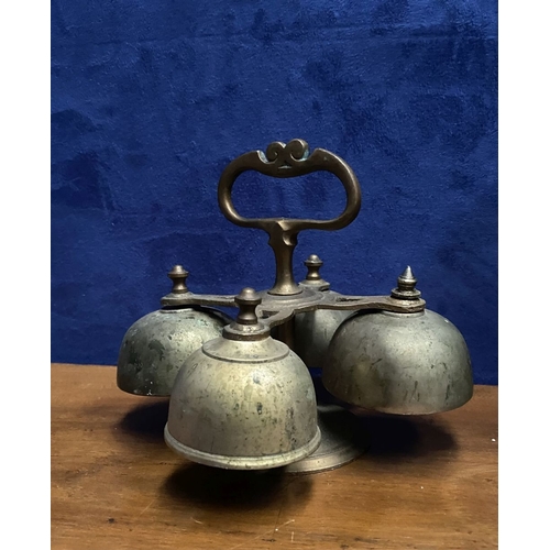 131 - AN ANTIQUE SACRISTY BELL, brass with handle, four bells, three with clappers, on circular base. Dime... 