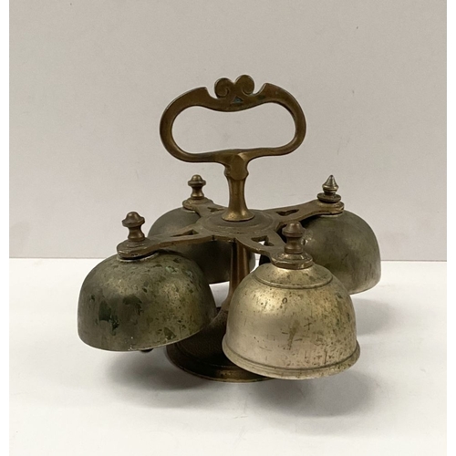 131 - AN ANTIQUE SACRISTY BELL, brass with handle, four bells, three with clappers, on circular base. Dime... 