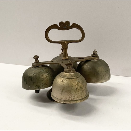 131 - AN ANTIQUE SACRISTY BELL, brass with handle, four bells, three with clappers, on circular base. Dime... 