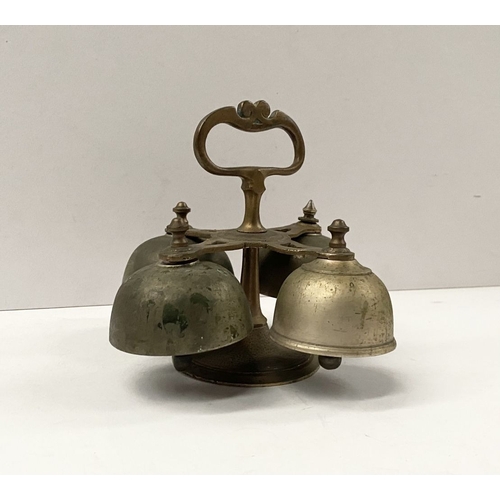 131 - AN ANTIQUE SACRISTY BELL, brass with handle, four bells, three with clappers, on circular base. Dime... 